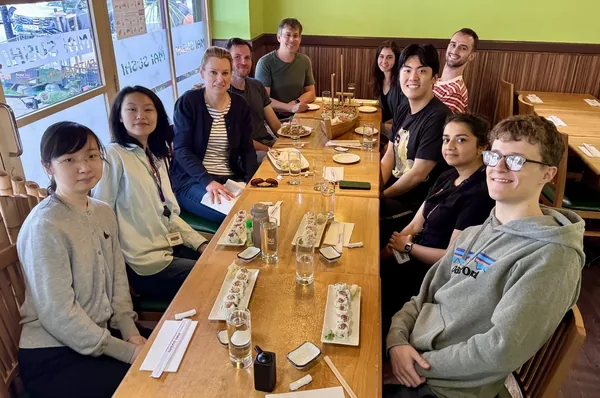 Lab members around a table at a sushi restaurant, 2025